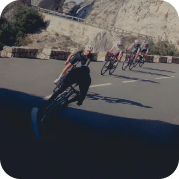 Cyclist aggressively leaning the bike into a tight corner, demonstrating the high clearance angle of the pedals